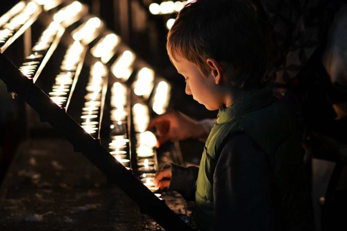 Bambino accende le candele in chiesa