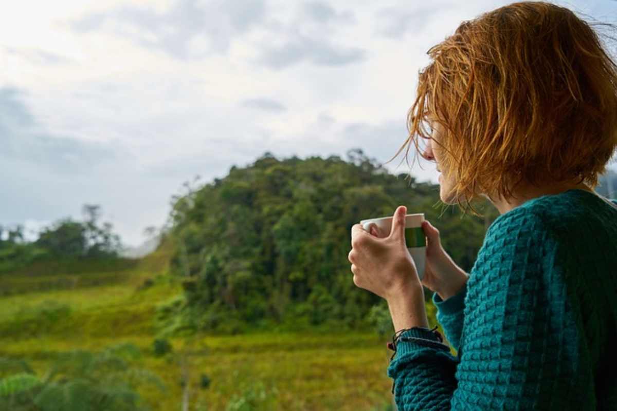 Donna beve un caffè nella natura