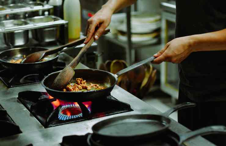 persona in cucina con padella